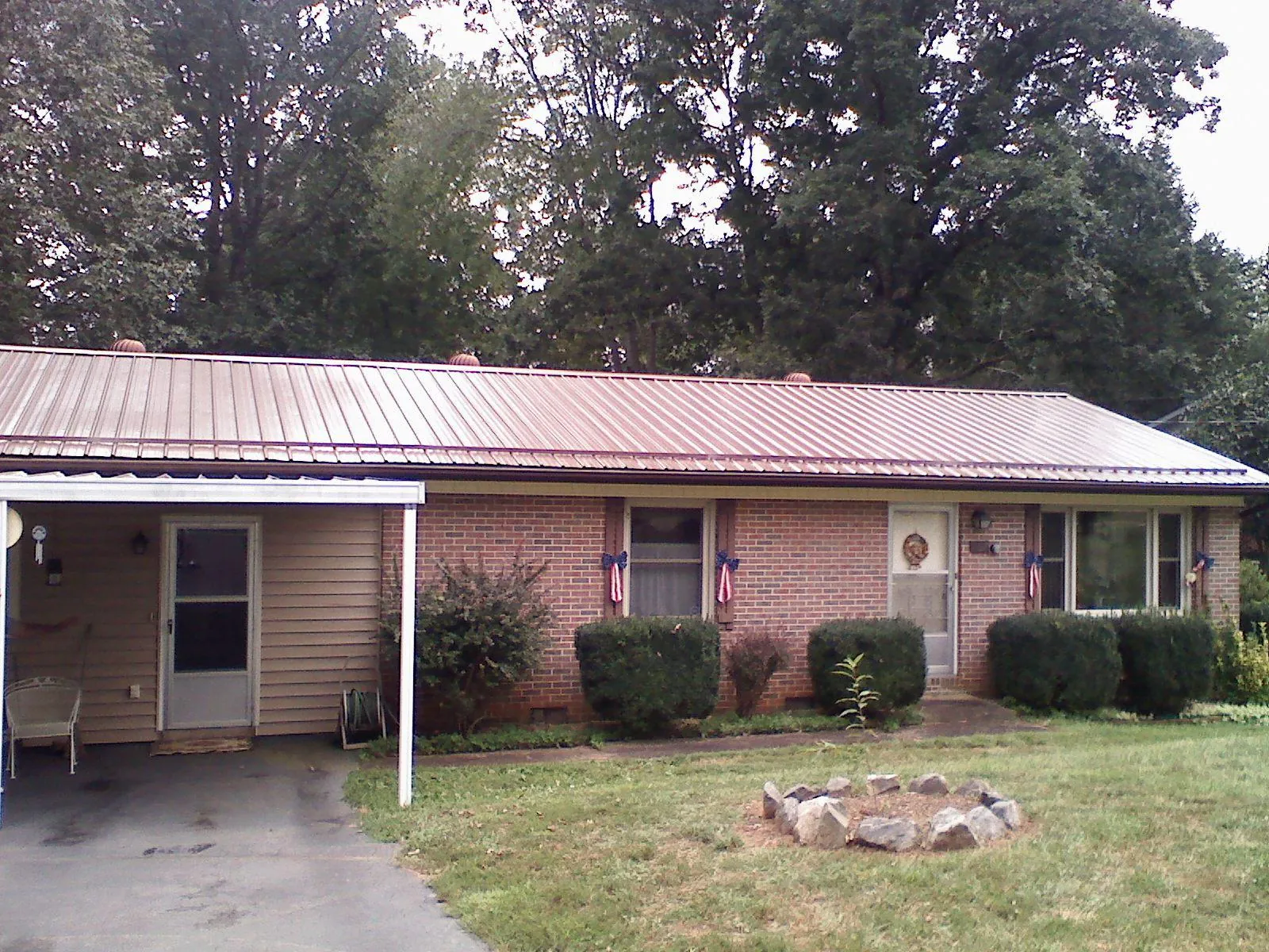 Bronze metal roof and carport on a brick ranch home — Roof Repair work by our crew in Agra